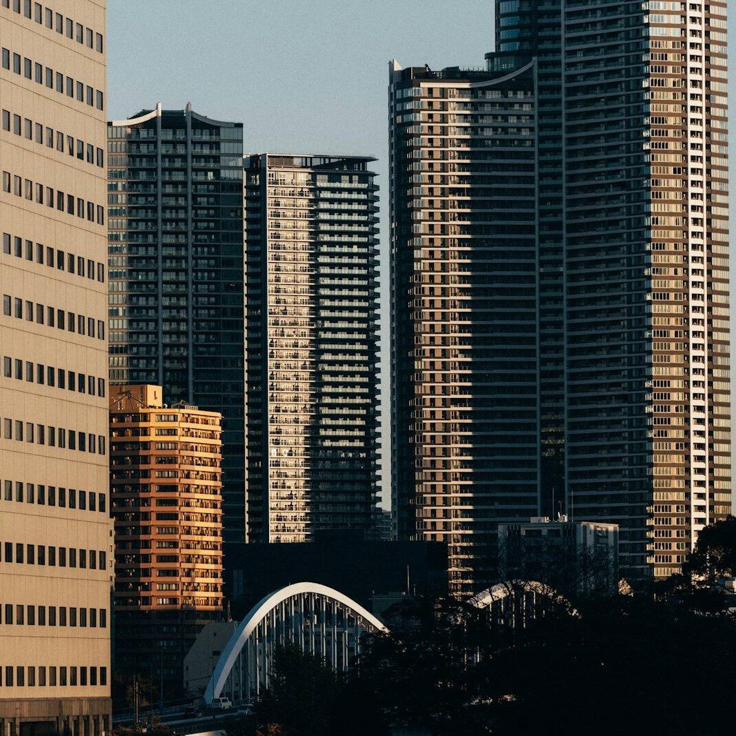 Skyscrapers tower over a bright, sunny city.